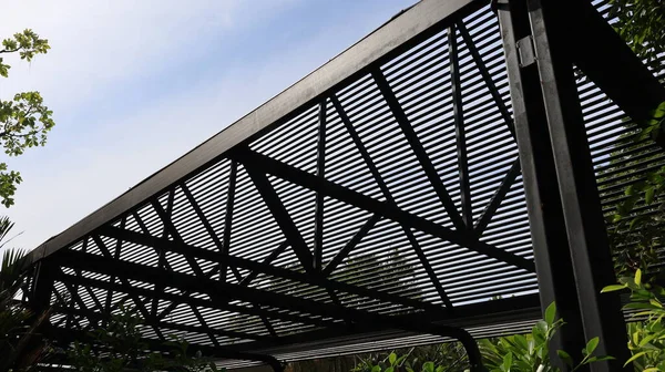 Hafif filtre çelik çatı yapısı. Modern evin siyah metal çatısı, yan görüntüdeki ışığı tam kare doğal arka planda filtreler. Seçici odak