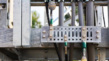 Kablolu gri zemin barı. Telekomünikasyon baz istasyonu yapısı üzerine kurulu metal panel kablosuz iletişim sistemindeki ekipmanların yıldırımdan kaynaklanan aşırı voltajdan korunması için. Seçici odak