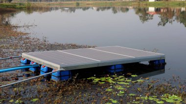 Suyun üstündeki güneş paneli. Kirli güneş paneli, su arka planında su pompalamak için elektrik üretmek için bir gölette su yüzdürür ve fotokopi alanı ile gölgelendirir. Seçici odak