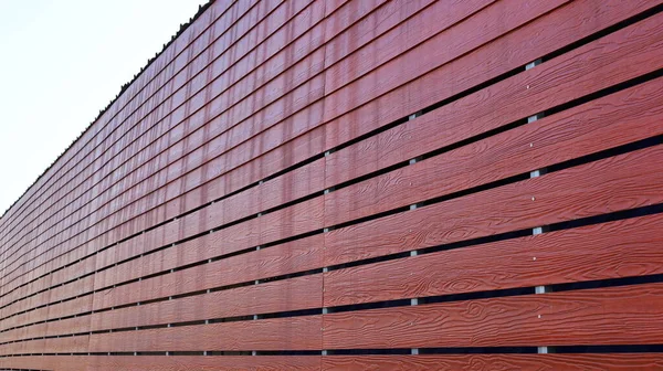 Horizontal red slat wall. Dark red artificial slat flooring, nailed for background and texture with copy space. Selective focus