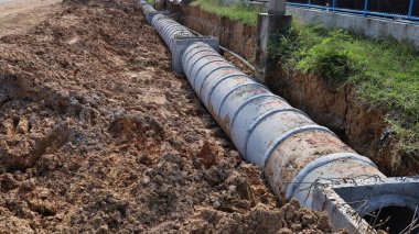 Beton boruyu çukura boşalt. Otoyolun yanındaki inşaat alanında kanalizasyon. Kopya alanı olan kentsel drenaj altyapısı. Seçici odak