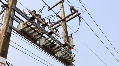 Kutuplardaki kapasitör bankaları. Mavi gökyüzü arka planında maksimum verimlilik ve düşük voltaj kaybı için güç iletim hatları üzerinde voltaj sabitleyici cihazların (AC veya DC) satırları. Seçici odak