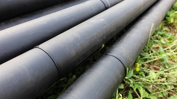 Welded joints on HDPE pipes. Polyethylene pipe piles with welded pipe connections raised on the ground side of the roadway with a copy area. Selective focus