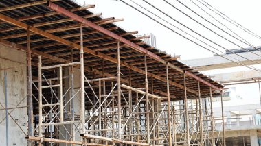 İnşaat alanındaki metal iskeleler. Geçici yapı iskelesi, yüksek binaların inşasına sıvı çimento dökmek için resmi destek olarak kullanılır. Seçici odak
