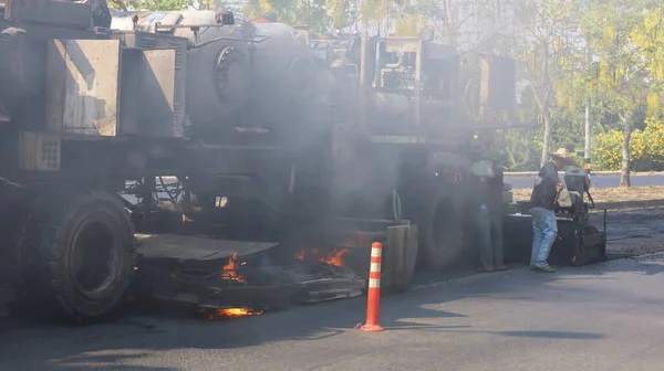 Yanan arabalardan çıkan duman ve yolları yeniden düzenlemek. Yol yüzeyindeki asfaltı eritmek için eski yol ısıtıcılarından çıkan duman fotokopi alanıyla remikslenir. Seçici odak
