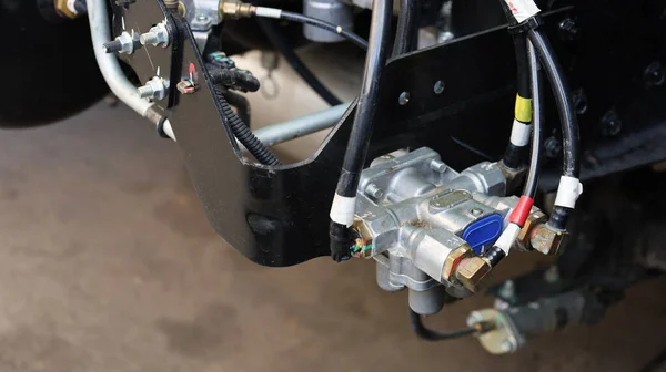 Kamyon hava freni vanası ve hava hortumu. Çimento deposunun arka planında, büyük bir kamyon veya otobüs fren sisteminde havayı kontrol etmek için kullanılan dört devreli koruma vanası. İçeriği seç ve odaklan