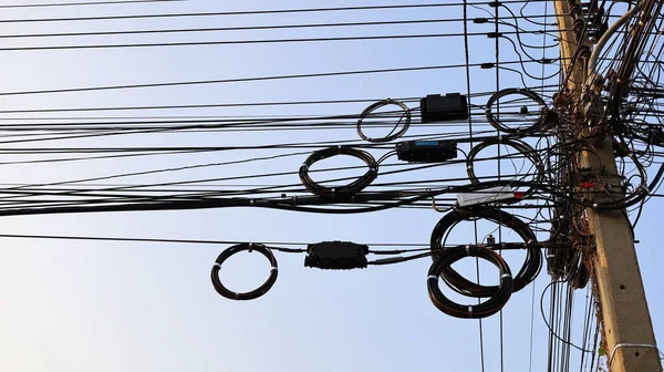 İnternet kablosu makarası ve elektrik kabloları üzerindeki kara kutu. Yüksek hızlı fiber optik kablo makaraları ve diğer kablolarla birlikte kutuda asılı çoklu fiber optik bölme kutusu (PIc). Seçici odak