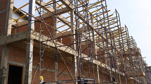 Metal scaffold on the side of the building under construction.steel scaffold structure in the unfinished building side view on the construction site on white sky background