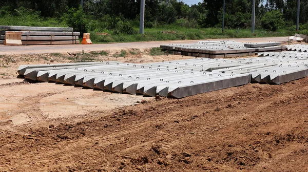 Reinforced concrete piles on the ground. High-strength prestressed concrete piles made of fast-hardening cement are placed side-by-side on a construction site with a copy area. select focus