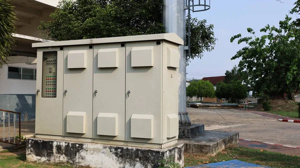 Stadyum ışıkları için kontrol dolabı. Sistemin fotokopi alanıyla açılıp kapanması için beton sütun tabanlı büyük bir açık hava kremi renkli metal dolap..