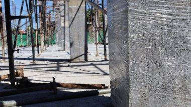 Temiz plastikle kaplı beton sütunlar. Nem buharlaşmasını kontrol etmek için betonun plastikle iyileştirilmesi yüksek güç ve dayanıklılık için tam hidrasyon reaksiyonu sağlar. Konuya odaklan