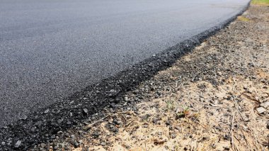 Yan görüşte Paved Yolu. Kopyalama alanı olan yeni inşa edilmiş ya da yenilenmiş asfalt yol yüzeyi. Seçici odak