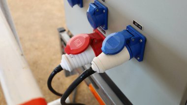 Jeneratörde kabloları olan elektrik prizi. Mavi ve kırmızı çift güç prizleri gri jeneratöre bağlı. Konuya odaklan