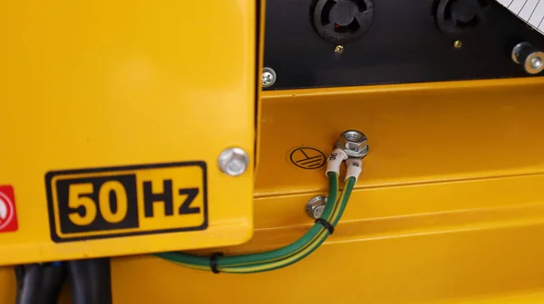 Ground wires on the generator. The nut and ground wire are mounted on the yellow secondary generator for short-circuit protection. Select focus and subject.