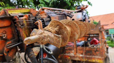 Arabaları delmek için matkap uçları. İnşaat sahalarında kazmak için hidrolik sistemlerle toprağı delmek için kullanılan kirli metal matkap uçları. Konuya yakın odağı seç.