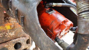 Kirli hidrolik motor. Eski kırmızı dengeleyici ve hidrolik yağ hortumu hidrolik enerjiyi mekanik enerjiye dönüştüren cihazlardır. İçeriği seç ve odağı kapat.