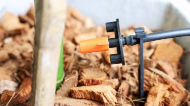 Mikro boru sulama hortumu. Tencerelerdeki bitkiler için ayarlanabilir sulama kapasitesine sahip turuncu plastik şişeler. Konulara yakından odaklan