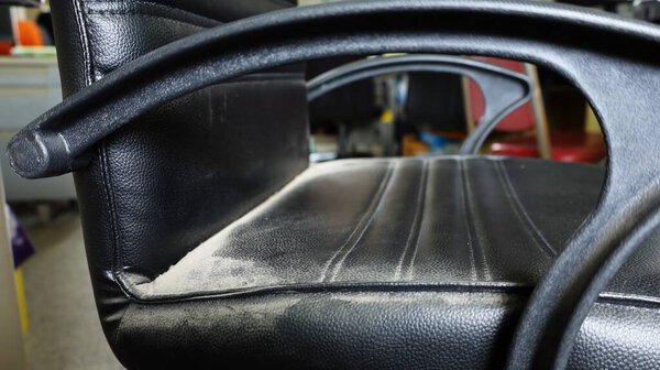 Close up dirty old chair. Black chair with dust stains due to lack of maintenance. Selective focus