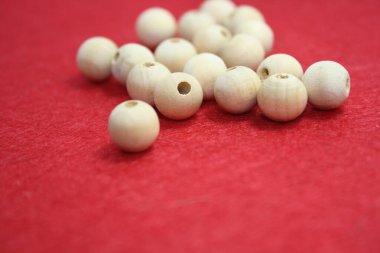 Kırmızı keçeli arka planda Woden boncukları. El işi. Metin için boşluk.