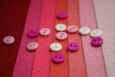 Pembe keçeli arka planda renkli düğmeler. Yapı