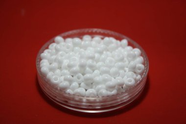 Kutuda beyaz boncuklar. Mesajın için yer aç. Kırmızı arkaplan.