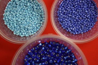 Kutudaki mavi boncuklar. Mesajın için yer aç. Kırmızı arkaplan.