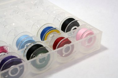 Dikiş makineleri için iplikli plastik bobinler. Çok renkli iplikler var. Metin için boşluk.