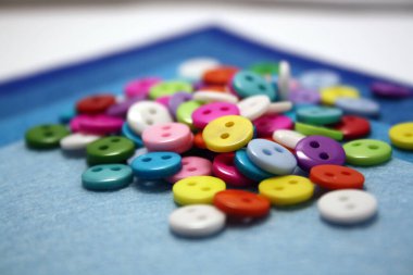 Mavi arka planda renkli düğme var. Metin için boşluk.