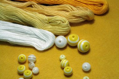 Keçeli arka planda nakış işlemek için boncuk ve dikiş iplikleri. Metin için boşluk.