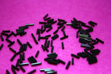 Pembe keçeli arka planda siyah boncuklar. Metin için boşluk.