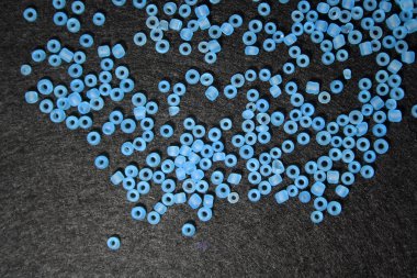 Siyah keçeli arka planda mavi boncuklar. Metin için boşluk.