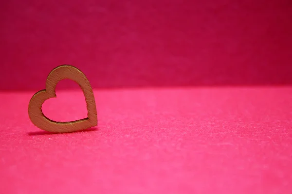 木製の心でバレンタインデーの背景 ピンクの背景 — ストック写真