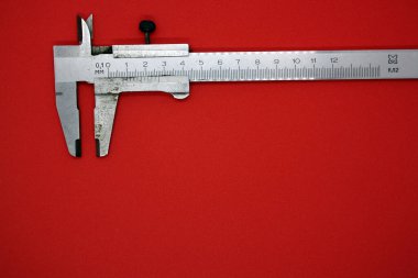 Kırmızı arka planda Vernier Caliper. Metin için boşluk.