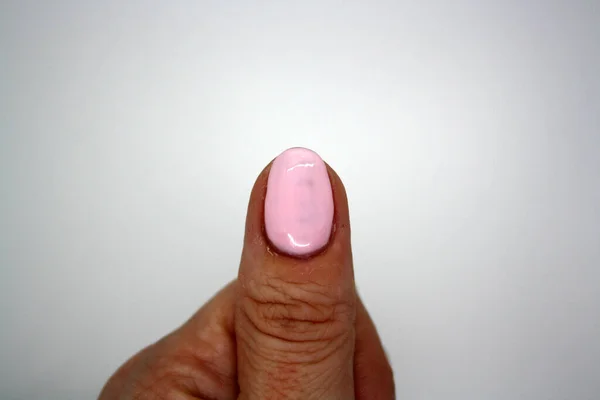 Duim Geschilderd Met Roze Vernis Een Witte Achtergrond Ruimte Voor Stockfoto
