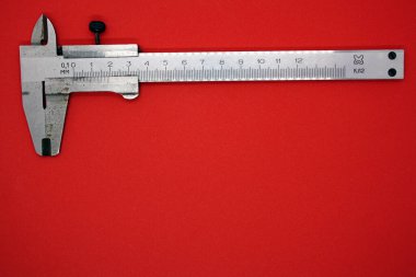 Kırmızı arka planda Vernier Caliper. Metin için boşluk.