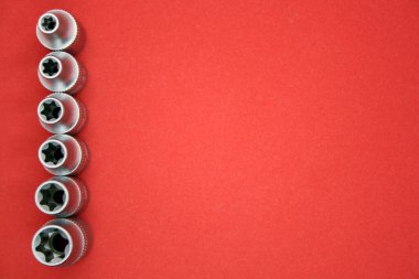 Kırmızı arkaplandaki tornavidalar için farklı boyutlarda bir set.