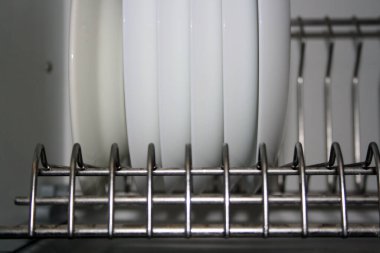 Beyaz tabaklar kurutucuda sıra sıra bekliyor. Metin için boşluk.