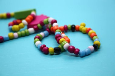 Mavi arka planda boncuklardan yapılmış bir bilezik. Metin için boşluk.