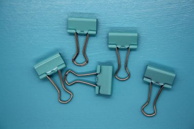 Mavi arka planda ataçlar. Metin için boşluk.