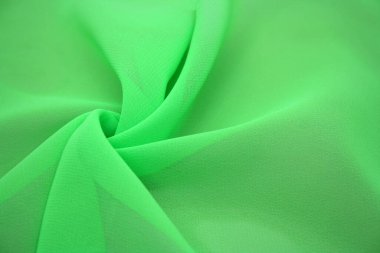 Arka plan dalgalar halinde duran sentetik kumaştan yapılmış. Yeşil renk.