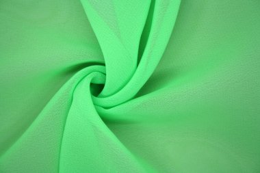 Arka plan dalgalar halinde duran sentetik kumaştan yapılmış. Yeşil renk.