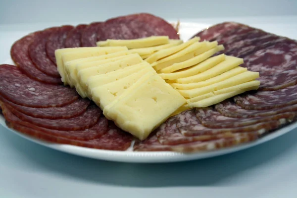 色拉米切片和奶酪在白盘上 案文的篇幅 — 图库照片