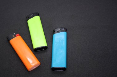 Siyah arka planda üç çakmak. Metin için boşluk.