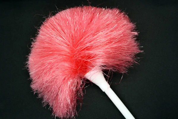 Pink dust brush on a black background. Space for text.