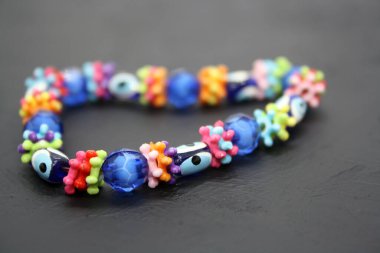 Siyah arkaplandaki boncuklardan yapılmış bir bilezik. Metin için boşluk.