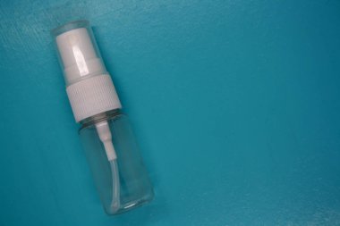 Mavi arka plandaki sprey şişesi. Metin için boşluk.