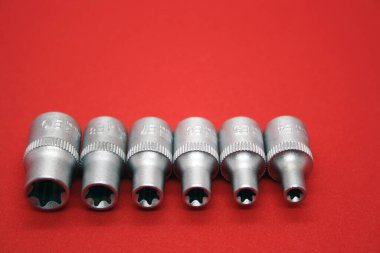 Kırmızı arkaplandaki tornavidalar için farklı boyutlarda bir set.