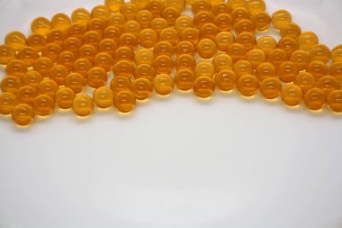 Beyaz arka planda balık yağı kapsülleri. Metin için boşluk.