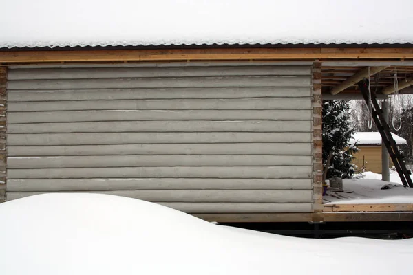 Gray house made of logs. Winter. White snow. Background for the text.