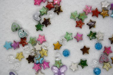 Beyaz tekstil arka planında renkli boncuklar. Metin için boşluk.